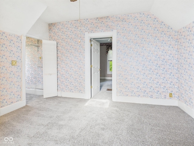 814 Walnut St, Anderson, IN 46012 - carpeted empty room featuring wallpapered walls, lofted ceiling, and baseboards