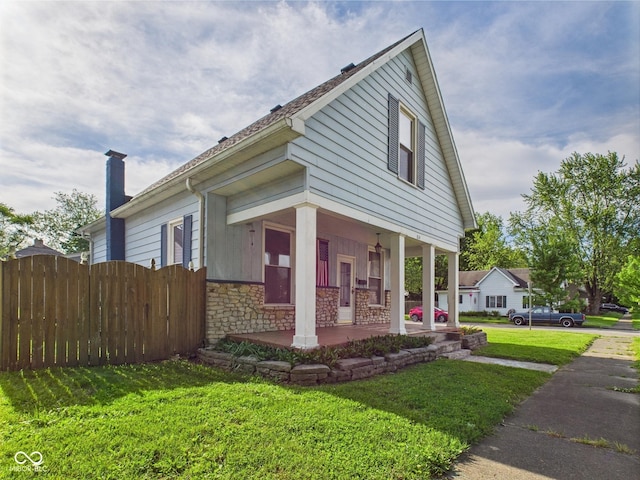 814 Walnut St, Anderson, IN 46012 - view of front facade with a porch, stone siding, and a chimney
