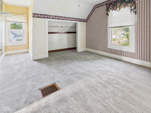 814 Walnut St, Anderson, IN 46012 - unfurnished bedroom with wallpapered walls, carpet flooring, vaulted ceiling, and a closet
