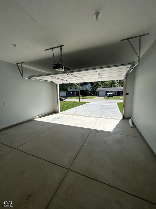 223 N Coventry Dr, Anderson, IN 46012 - garage featuring a garage door opener and baseboards