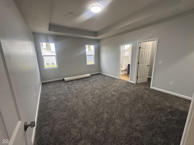 223 N Coventry Dr, Anderson, IN 46012 - unfurnished room with a raised ceiling, dark carpet, and baseboards