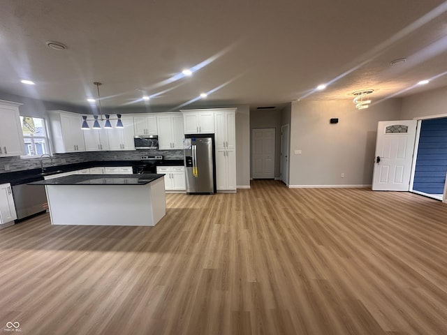 223 N Coventry Dr, Anderson, IN 46012 - kitchen with appliances with stainless steel finishes, dark countertops, tasteful backsplash, light wood-type flooring, and white cabinets