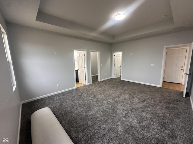 223 N Coventry Dr, Anderson, IN 46012 - unfurnished bedroom with a tray ceiling, carpet, baseboards, and ensuite bathroom