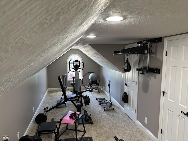 workout area featuring a textured ceiling, baseboards, and carpet