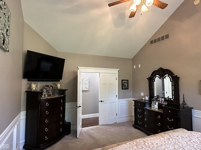 carpeted bedroom featuring a wainscoted wall, high vaulted ceiling, and ceiling fan