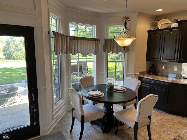 dining area featuring light tile patterned flooring and ornamental molding