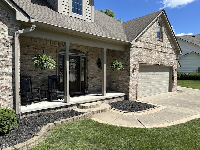 doorway to property with covered porch, driveway, brick siding, and a shingled roof