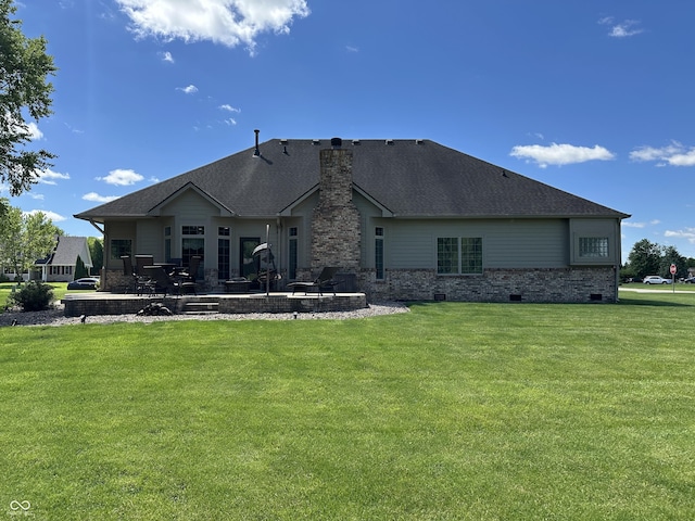 back of house featuring a patio area, a chimney, a lawn, and a shingled roof