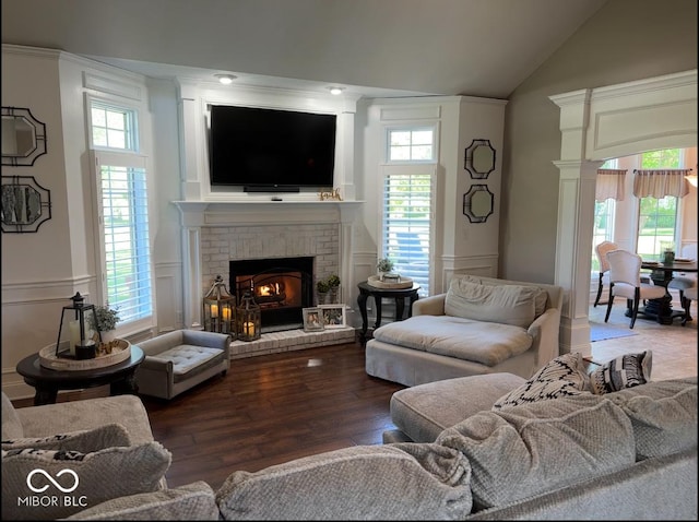 living room with high vaulted ceiling, wood finished floors, a decorative wall, a fireplace, and wainscoting