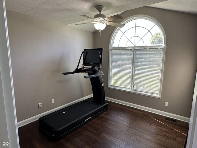 workout area with a textured ceiling, wood finished floors, baseboards, and a ceiling fan
