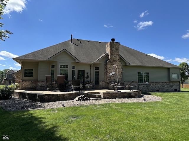 rear view of house featuring a patio area, a yard, a chimney, and a shingled roof