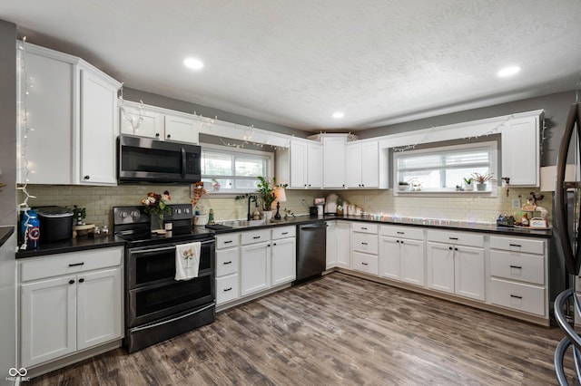 kitchen with black appliances, dark countertops, backsplash, white cabinets, and recessed lighting