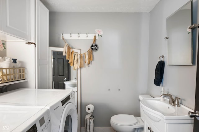 bathroom with washer and clothes dryer, toilet, and vanity