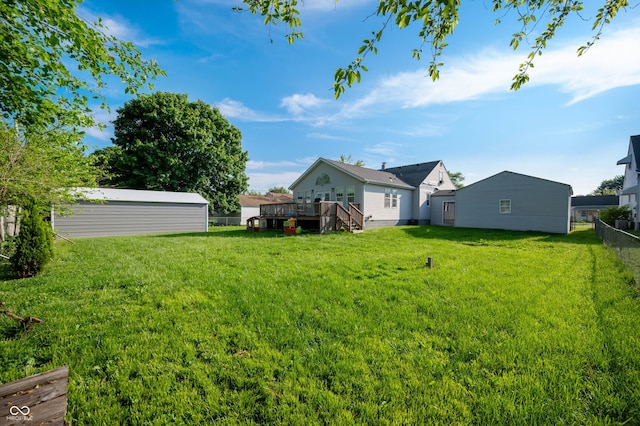 view of yard with a deck and an outbuilding