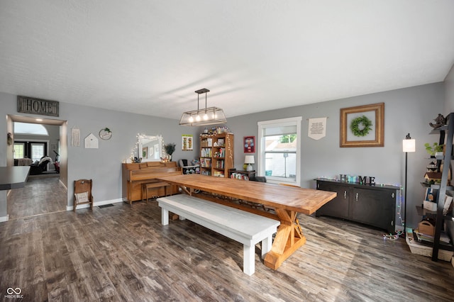 dining room featuring healthy amount of natural light, wood finished floors, and baseboards