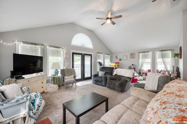 carpeted living area with ceiling fan, french doors, and high vaulted ceiling