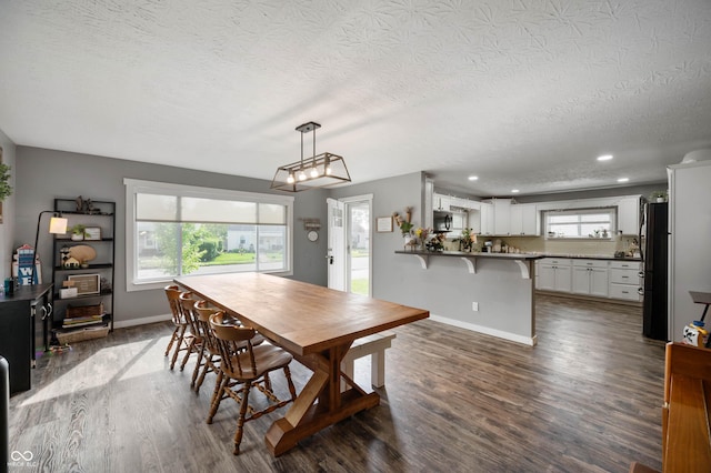 dining room with a textured ceiling, dark wood-style flooring, baseboards, and recessed lighting