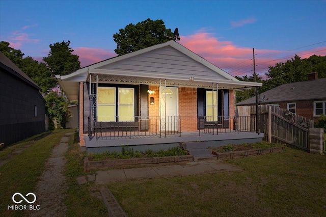1170 N Concord St, Indianapolis, IN 46222 - view of front of house with a porch, brick siding, and a front lawn