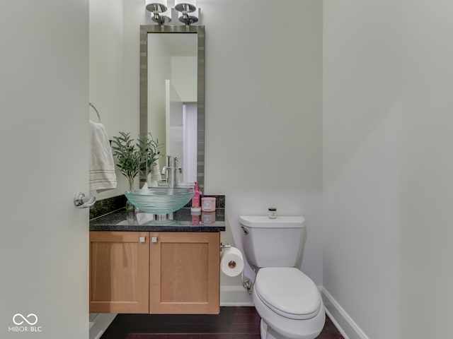222 N E St Unit 103, Indianapolis, IN 46204 - half bathroom featuring toilet, vanity, and baseboards
