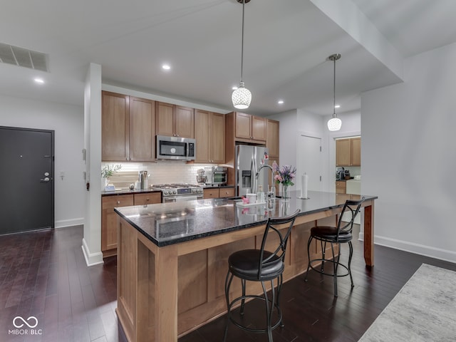222 N E St Unit 103, Indianapolis, IN 46204 - kitchen with stainless steel appliances, dark wood-type flooring, baseboards, a spacious island, and recessed lighting