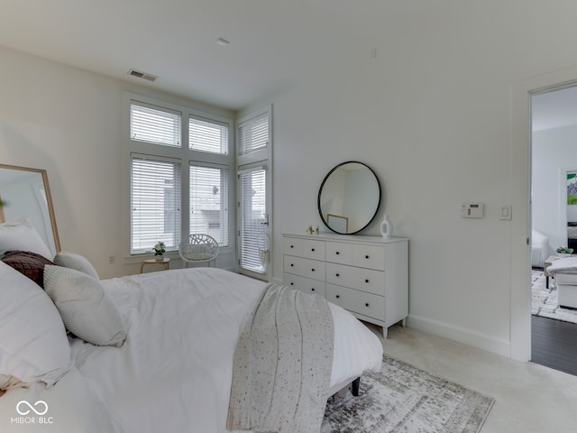 222 N E St Unit 103, Indianapolis, IN 46204 - bedroom with light carpet, baseboards, and access to outside