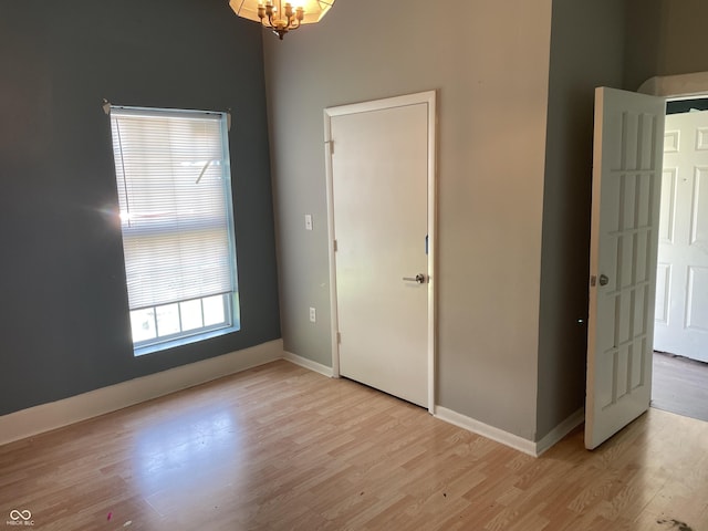 1164 Groff Ave, Indianapolis, IN 46222 - empty room featuring light wood-style flooring, baseboards, and a chandelier