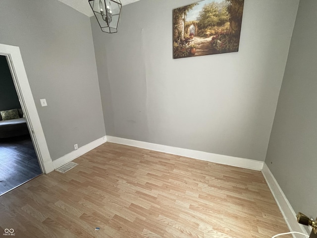 1164 Groff Ave, Indianapolis, IN 46222 - unfurnished dining area with wood finished floors, a chandelier, and baseboards