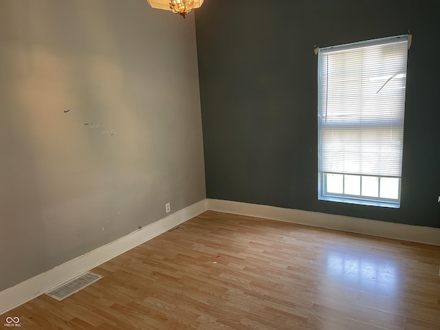 1164 Groff Ave, Indianapolis, IN 46222 - empty room with baseboards, light wood-type flooring, and a chandelier