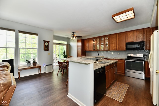 938 Weeping Way Ln, Avon, IN 46123 - kitchen with black appliances, a sink, brown cabinets, open floor plan, and dark wood-type flooring