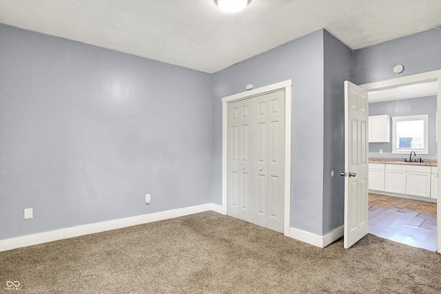 3109 E St Joseph St, Indianapolis, IN 46201 - unfurnished bedroom with a sink, light colored carpet, baseboards, and a closet