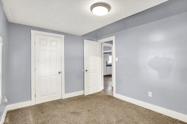 3109 E St Joseph St, Indianapolis, IN 46201 - unfurnished bedroom featuring baseboards, carpet floors, and a textured ceiling