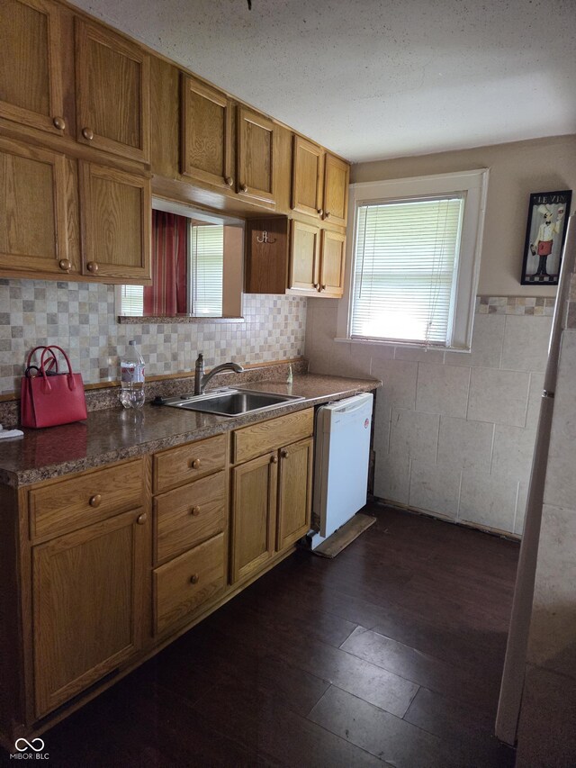 1168 N Gladstone Ave, Indianapolis, IN 46201 - kitchen featuring white dishwasher, a sink, dark wood-style flooring, and brown cabinetry
