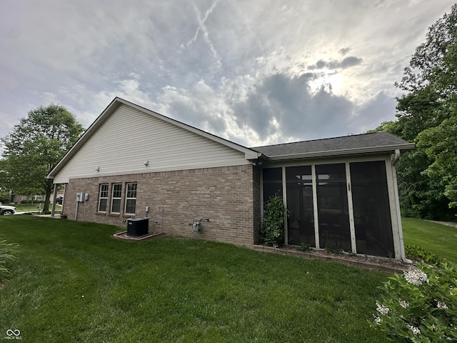 5486 Lipizzan Ln, Plainfield, IN 46168 - rear view of property featuring brick siding, a yard, a sunroom, and central air condition unit