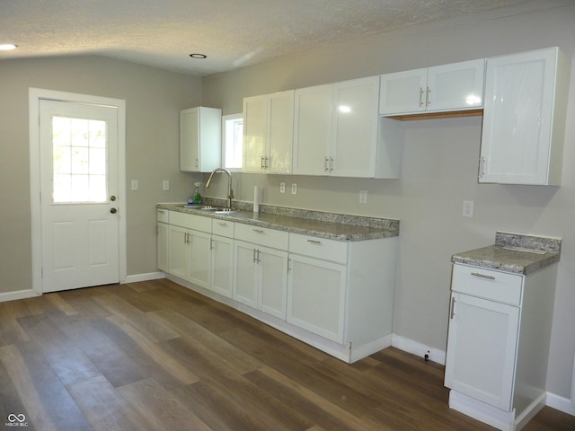 2007 Park Ave, Anderson, IN 46016 - kitchen featuring a textured ceiling, white cabinetry, dark wood-type flooring, a sink, and baseboards