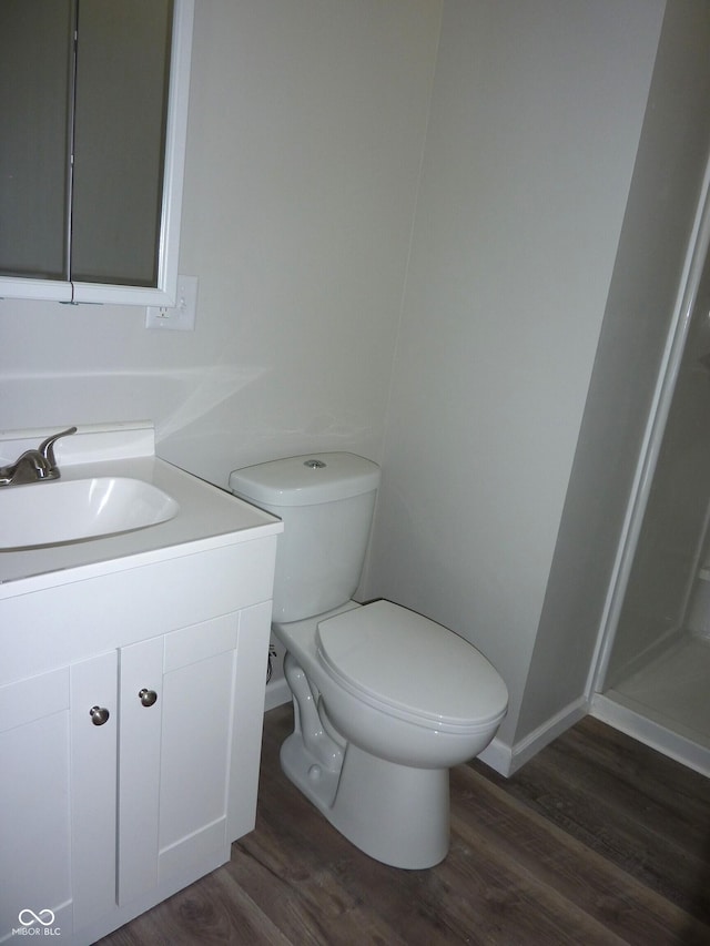 2007 Park Ave, Anderson, IN 46016 - bathroom with wood finished floors, toilet, vanity, baseboards, and a shower
