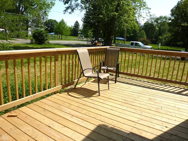 2007 Park Ave, Anderson, IN 46016 - wooden terrace featuring a playground, a lawn, and view of wooded area
