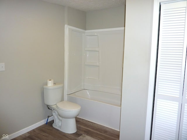 2007 Park Ave, Anderson, IN 46016 - bathroom featuring wood finished floors, toilet, tub / shower combination, and baseboards