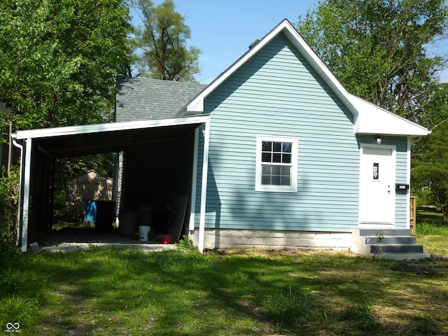 2007 Park Ave, Anderson, IN 46016 - rear view of house featuring a carport, entry steps, a yard, and an outbuilding