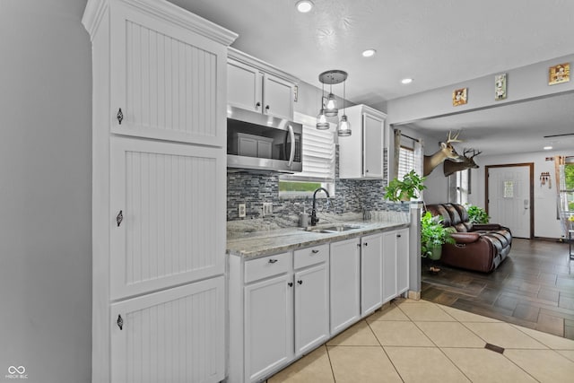 805 Sunvista Dr, Avon, IN 46123 - kitchen featuring stainless steel microwave, a sink, backsplash, white cabinetry, and recessed lighting