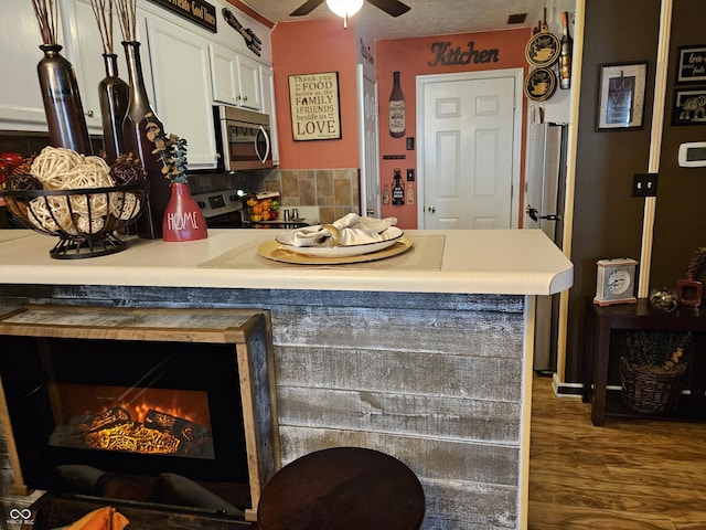 4962 Potomac Square Pl, Indianapolis, IN 46268 - kitchen featuring appliances with stainless steel finishes, ceiling fan, white cabinets, wood finished floors, and light countertops