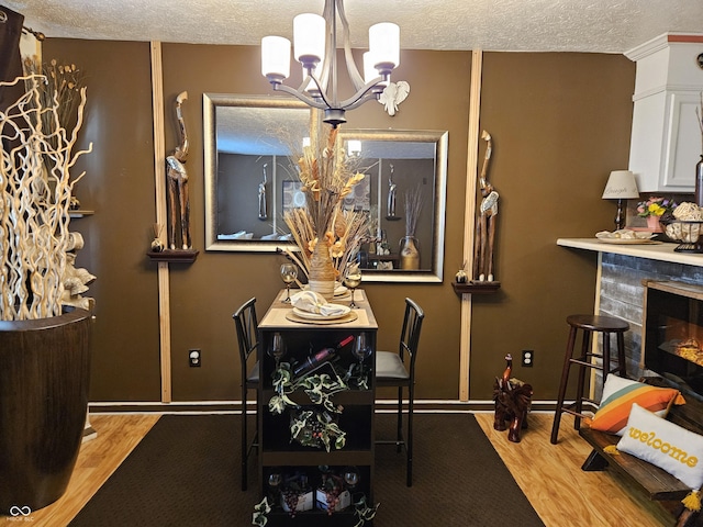 4962 Potomac Square Pl, Indianapolis, IN 46268 - dining room featuring a chandelier, a textured ceiling, wood finished floors, a tile fireplace, and baseboards