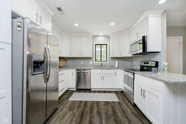3852 Knollton Rd Unit 3852, Indianapolis, IN 46228 - kitchen featuring appliances with stainless steel finishes, dark wood finished floors, white cabinets, light stone countertops, and recessed lighting