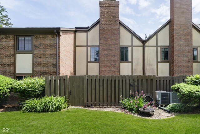 3852 Knollton Rd Unit 3852, Indianapolis, IN 46228 - view of side of property with stucco siding, central AC, brick siding, and a chimney