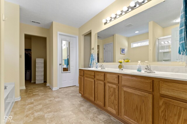 5145 Greenside Dr, Indianapolis, IN 46235 - full bath with baseboards, double vanity, a bath, a shower, and stone finish floors