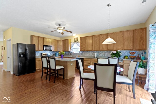 5145 Greenside Dr, Indianapolis, IN 46235 - kitchen featuring black appliances, a center island, backsplash, and light countertops
