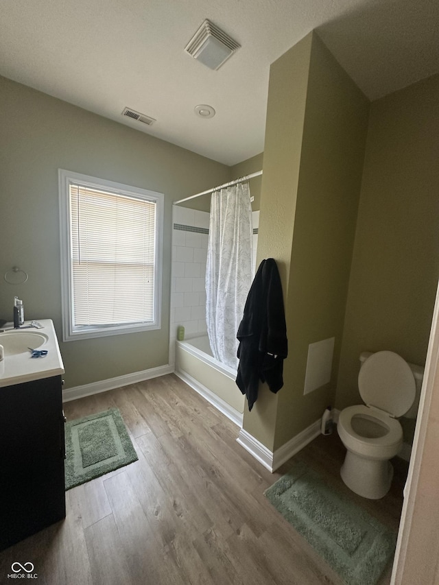 1128 S Pennsylvania St, Indianapolis, IN 46225 - bathroom featuring wood finished floors, shower / bath combo with shower curtain, toilet, vanity, and baseboards