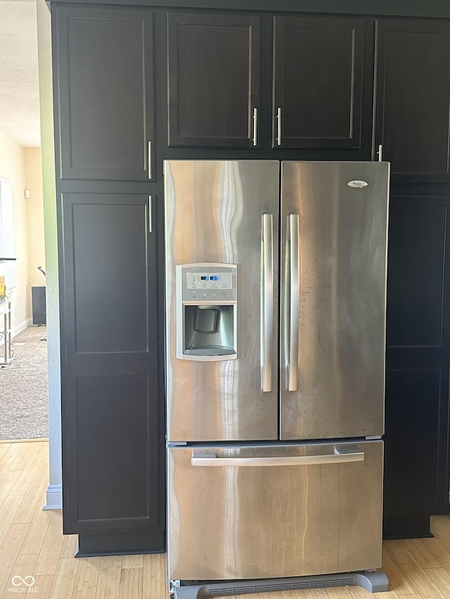 1128 S Pennsylvania St, Indianapolis, IN 46225 - kitchen with stainless steel fridge with ice dispenser, light wood finished floors, dark cabinets, and baseboards