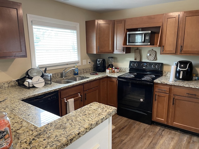 1931 E 68th St, Indianapolis, IN 46220 - kitchen with black appliances, a sink, light wood-style floors, light stone countertops, and brown cabinets