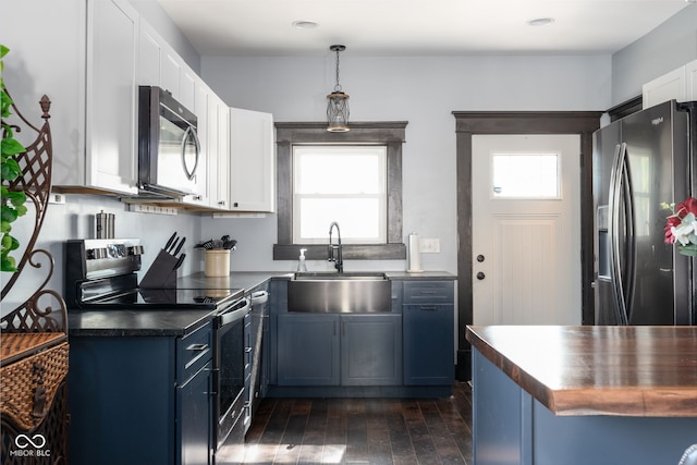 2215 S Delaware St, Indianapolis, IN 46225 - kitchen with stainless steel appliances, a sink, dark countertops, white cabinetry, and healthy amount of natural light