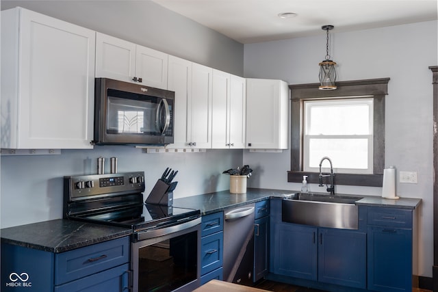 2215 S Delaware St, Indianapolis, IN 46225 - kitchen with stainless steel appliances, blue cabinets, a sink, dark countertops, and white cabinetry